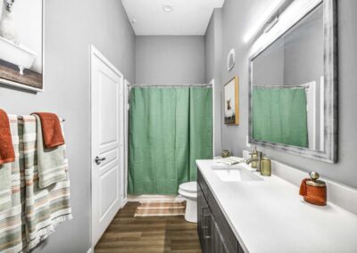 bathroom with wood-style flooring, ample lighting and towel rack