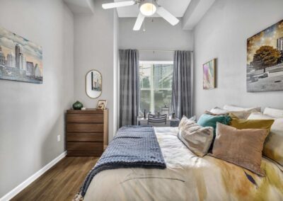 bedroom with ceiling fan, wood-style flooring and large window