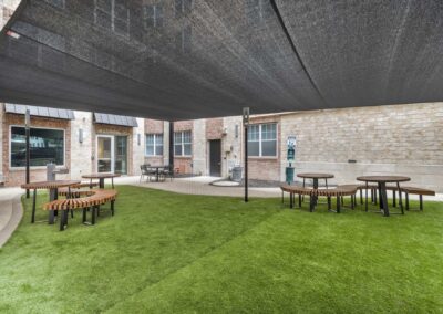 outdoor, covered pet area with turf and brick walkway