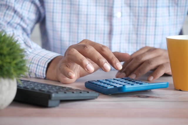 close up photo of a man using a blue calculator